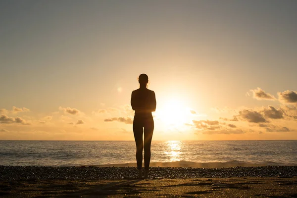 Einsame menschliche Silhouette auf dem Meer Kosten Blick auf den Sonnenuntergang über einem Wasser. — Stockfoto