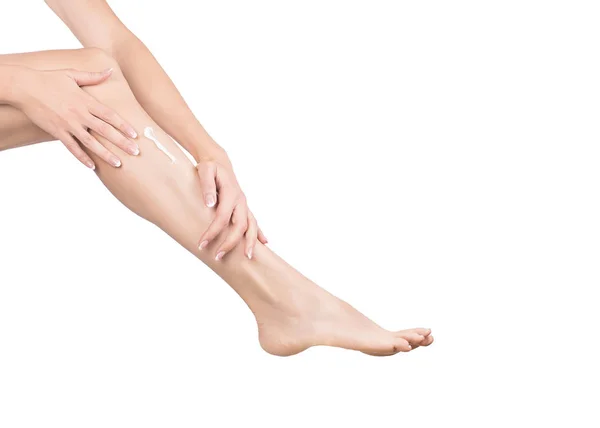 Mãos femininas massagem perna feminina com creme, close-up — Fotografia de Stock