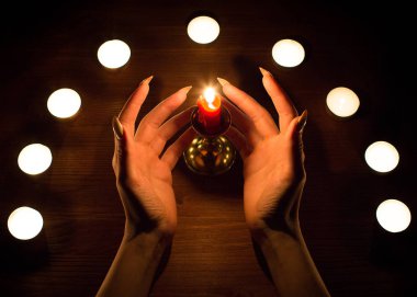 Mumlar ve eller ile keskin tırnakları. Kehanet ve büyücülük, düşük anahtar.