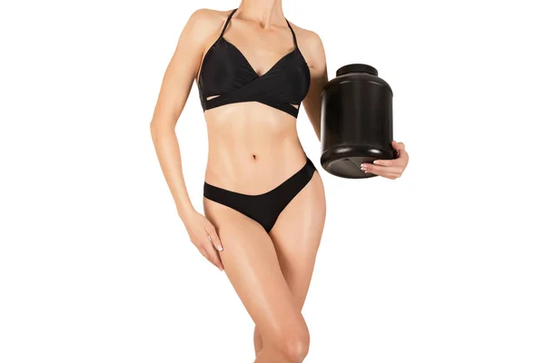 Cuerpo de corte bronceado sexy femenino en top negro y bragas con gran tarro de plástico de nutrición deportiva, aislado en blanco — Foto de Stock