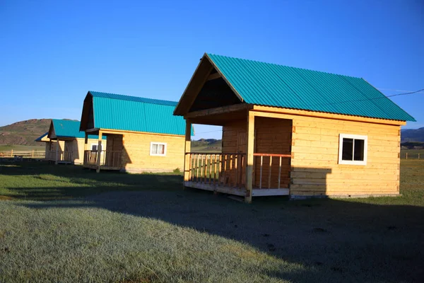 Geometrical figures in bright wooden small houses on a camp site in the Altay mountains