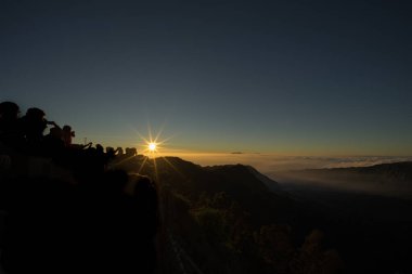 Sabah günün ilk ışıklarıyla, görmek için bekleyen insanlar taç