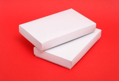 Kırmızı bir arka plan üzerinde beyaz karton kutular