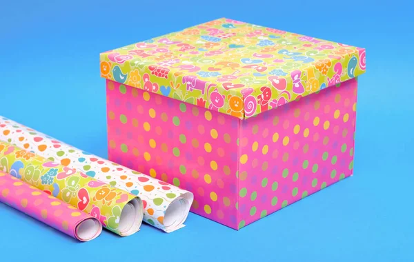 Bright gift box, and rolls of paper, blue background
