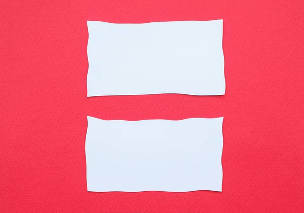 Two business cards on red paper background