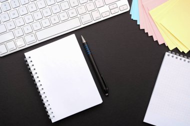 Üstten görünüm ile kopya yer-in iş nesneleri için bir çalışma ile bir ofis masası. Siyah Kağıt arka plan.