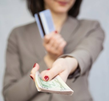 Dolar ve kredi kartı, gri arka plan iş kadını