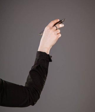 Gri zemin üzerine kalem tutan kadının el