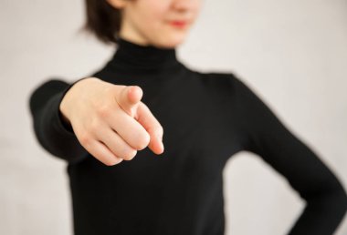 Stern gesture of an unrecognizable young woman, neutral background clipart