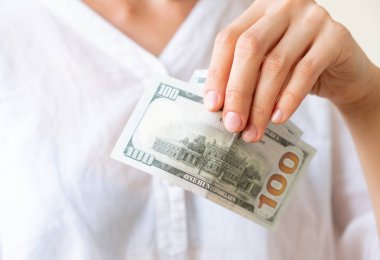 Kadın eli iki yüz-in dolar, nötr arka plan düzenliyor