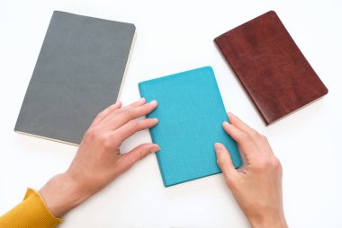 Eller arasında üç farklı, beyaz arka plan mavi bir günlüğü/defter seçin