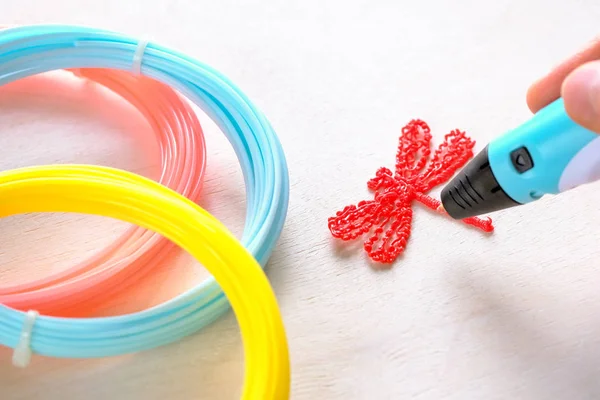 İnsan eli bir kırmızı plastik yusufçuk bir Abs/Pln plastik tutar. Makro çekim.
