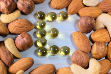 Fındık ve E vitamini, ahşap arka plan ile kapsül