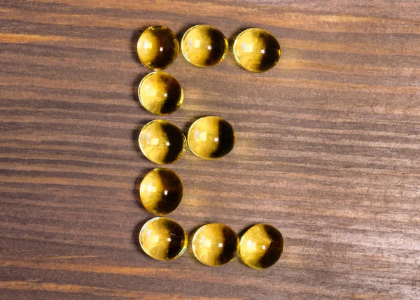 E vitamini, ahşap arka plan ile kapsül