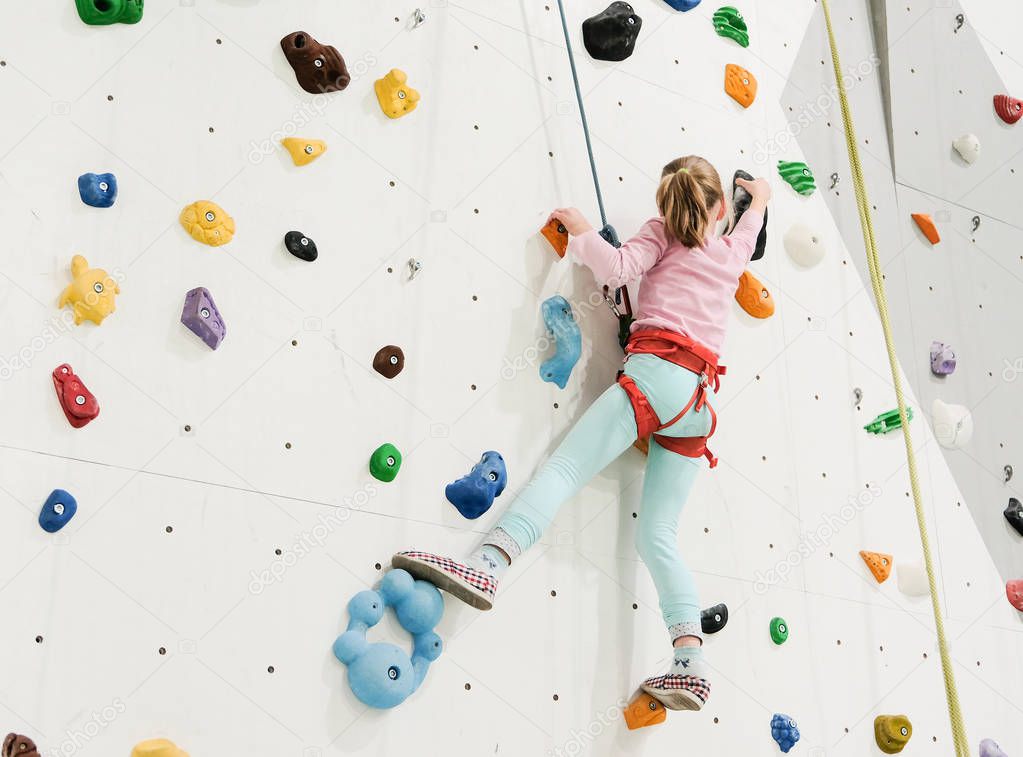 Active caucasian girl on the climbing wall