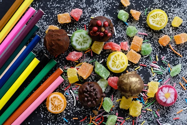 Sweets and pencils on sugarly background — Stock Photo, Image