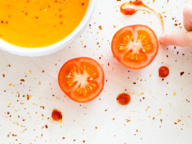 Biber biber ile bir kase sıcak krem çorbası. Bir çocuk domates sosu ile çizer. Beyaz arka plan.