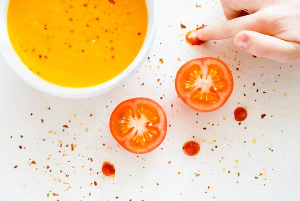 Biber biber ile bir kase sıcak krem çorbası. Bir çocuk domates sosu ile çizer. Beyaz arka plan.