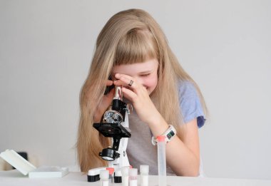 Öğrenci mikroskopla bir deney yapar.