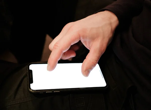 Hombre irreconocible utiliza un teléfono inteligente, fondo negro — Foto de Stock