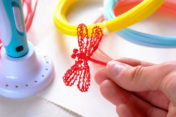 İnsan eli bir Abs / Pln plastik kırmızı plastik yusufçuk tutar