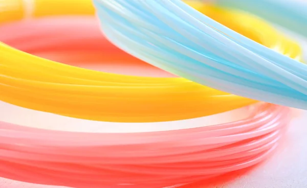 ABS plastic (yellow, blue, pink) on a whte background.