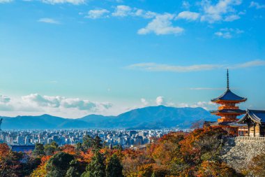 Kiyomizu-dera ' l A ön planda renkli akçaağaç yaprakları ve Pagoda ile Kyoto şehrinin çarpıcı panoramik manzarası.
