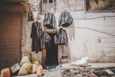 Birkaç ceketli bir sokak sahnesi Leh, Hindistan 'da kurutulduğu için duvarın dışına asıldı..