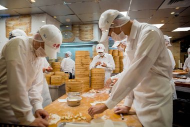 Taipei, Tayvan - 23 Mayıs 2018: Din Tai Fung'Un Taipei 101 restoranında açık mutfakta ünlü çorba köftesi yapmakla meşgul olan bir grup usta şef