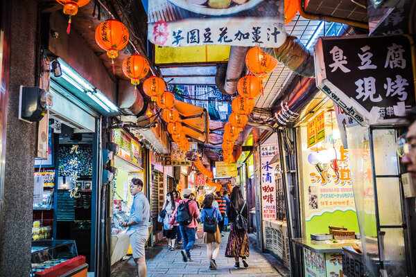 Цзючжоу, Тайвань - 6 июня 2018 года: оживленная уличная сцена с многочисленными туристами, гуляющими по узкой торговой улице в Цзючжоу
.