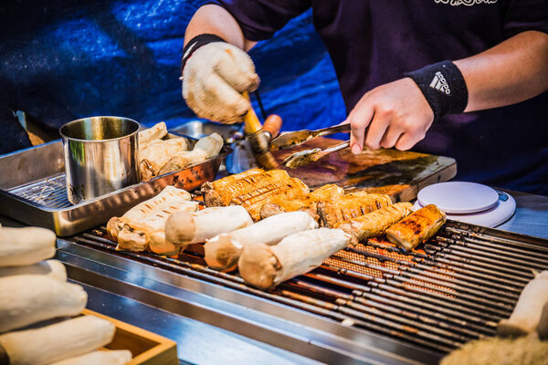 На ночном рынке Фэнцзя продаются жареные королевские устричные грибы на палочках
.