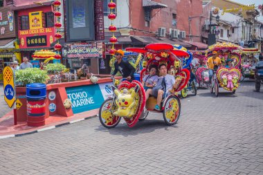 Malacca, Malezya - 26 Temmuz 2019: Renkli trishaws, bisiklet motorlu rickshaw, Melaka kasabasında gezinen bir tür. Her sürücü triportörünü parlak çiçekler, yanıp sönen ışıklar, bayraklar ve hediyeliklerle süsler..