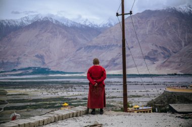 Diskit, Nubra Vadisi, Jammu ve Kashmir, Hindistan - 21 Haziran 2019: Himalayalar ve Karakoram 'ın Diskit Manastırı' ndaki manzarasını gözden kaçıran bir Budist keşiş. 