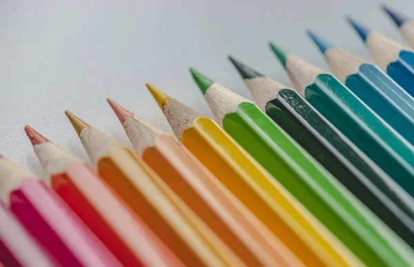 Different colored drawing pencils on light background