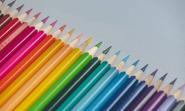 Different colored drawing pencils on light background