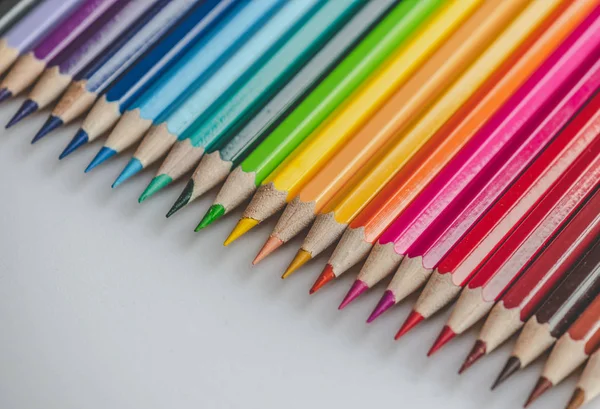 Different colored drawing pencils on light background