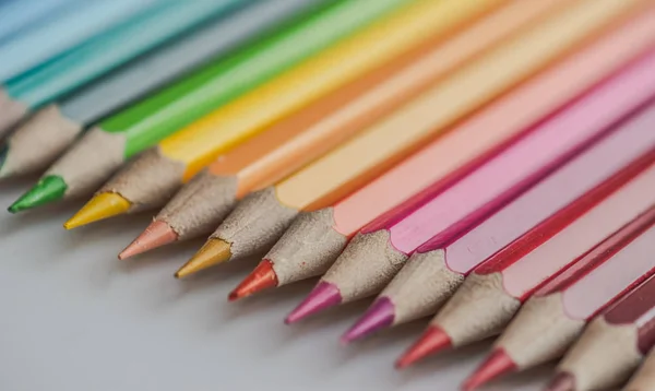 Different colored drawing pencils on light background