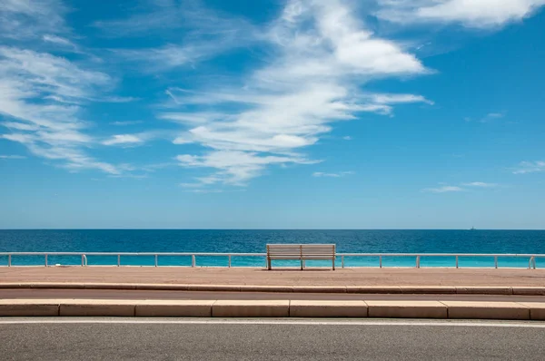 Yalnız bir Bank güneşli yaz gününde sonsuz mavi deniz kıyısında. Minimalizm.