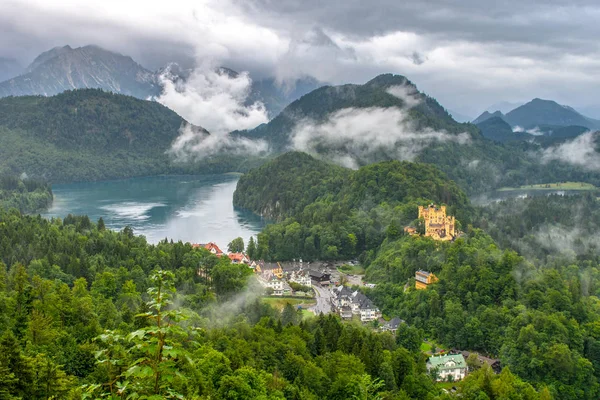 Royal castle bir dağ Gölü kıyısında. Fırtınalı gökyüzü ve sis karşı orman kaplı dağlar.