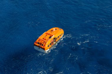 Mavi deniz dalgaları arka plan turuncu kurtarma teknesi. Havadan görünüm