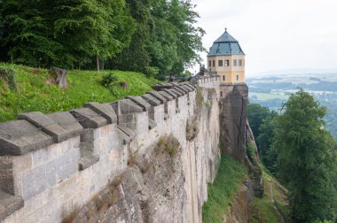 Kale duvarı ve ovaların üzerindeki bir uçurumun üzerinde eski bir ortaçağ kalesinin kulesi.
