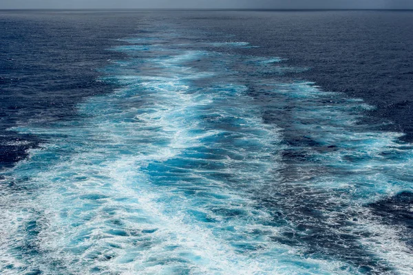 地平線に対する船の船尾の後ろの海の泡の道 — ストック写真