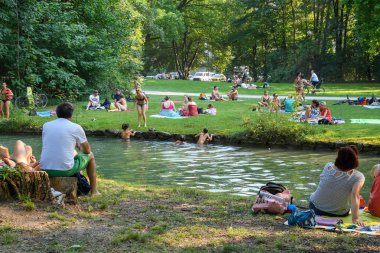 Münih, Almanya - Ağustos 2018: Anormal sıcak hava. İnsanlar şehir Parkı'nın serin nehrinde sıcaktan kaçıyorlar..