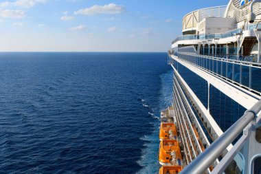 Mavi Atlantik okyanusu ve mavi gökyüzünde ufuk üzerinde beyaz bulutlar yolcu gemisi perspektif ve turuncu filikalar ile.