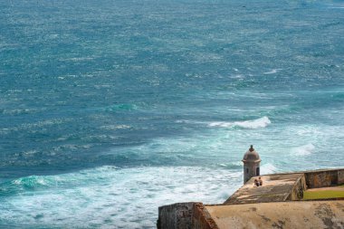 Sevgi dolu çift, antik Fort San Felipe del Morro'nun duvarında uçsuz bucaksız mavi Atlantik Okyanusu'nun arka planında yalnızlık içinde rahatlar. San Juan, Puertro Rico.