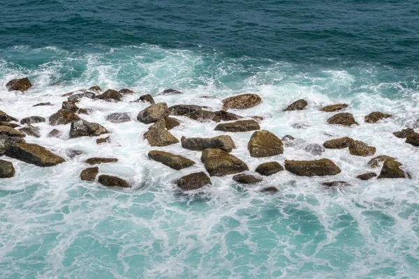 Resifler mavi okyanus dalgalarında beyaz deniz köpüğüyle kaplı. Close. Kavram.