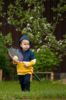 Küçük bir çocuk ve tenis raketi.