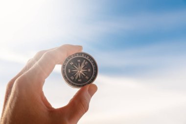 Parlak güneş ışığı önünde elinde bir pusula tutarak hayatta oryantasyon kavramı