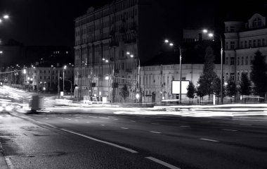 Uzun pozlama, arka plandaki trafik ışıkları, siyah beyaz posterler. 