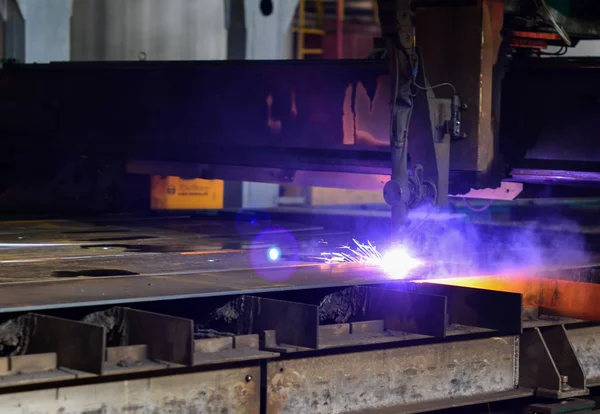 Cutting metal with plasma equipment. Worker cutting steel pipe using metal torch and install roadside fence. Electric sparklers background.